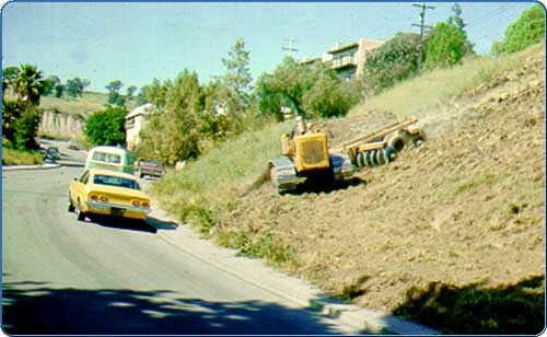 A method of weed removal which involves a series of concave discs pulled by a tractor that dig into the soil, lifting and turning over the weeds.